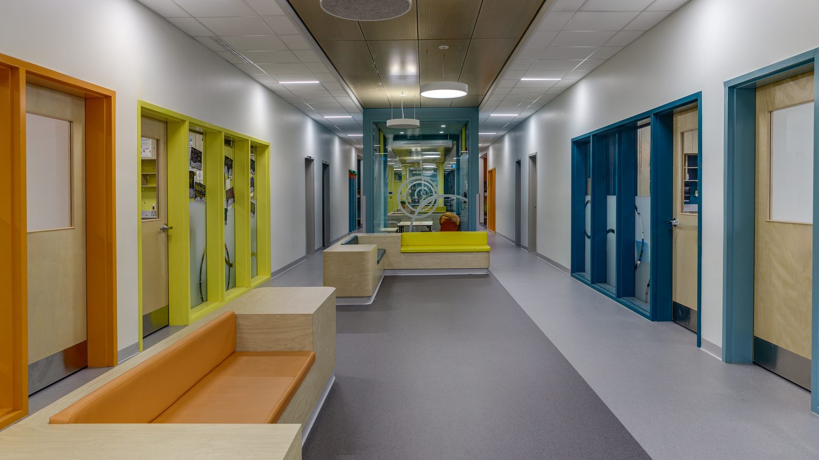 Corridor avec casiers et portes colorées de l’école Les Perséides